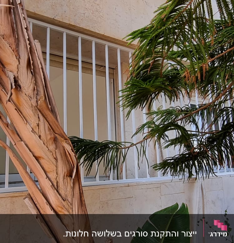 סורגי מתכת לבנים על חלון קיר חיצוני